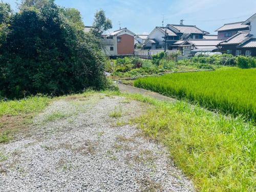 a dirt road next to a field with houses at えん飛鳥　日本始まりの地　古民家一棟貸し　8人＋大型犬も宿泊可能 in Asuka
