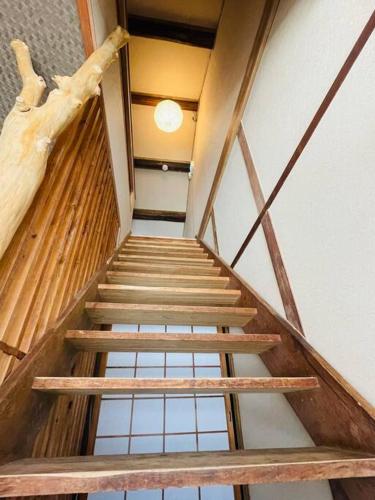 a wooden staircase in a building with a log at えん飛鳥　日本始まりの地　古民家一棟貸し　8人＋大型犬も宿泊可能 in Asuka