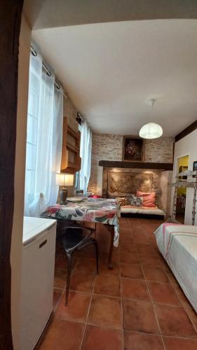 - une cuisine avec une table et un lit dans une chambre dans l'établissement Oh P'tit Rapporteur, à Montcuq