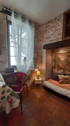 une chambre avec un lit, une chaise et une fenêtre dans l'établissement Oh P'tit Rapporteur, à Montcuq