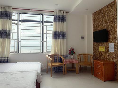 een slaapkamer met een bed en een tafel en stoelen bij Thăng Long Hotel in Dong Hoi