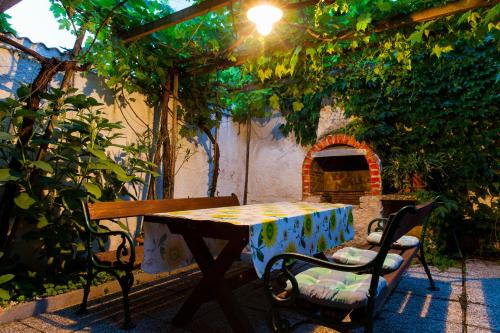 a table and chairs in a garden with a brick oven at Haus Akazie in Apetlon