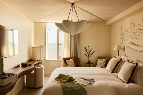 sypialnia z dużym białym łóżkiem i oknem w obiekcie No 42 by GuestHouse, Margate w mieście Margate