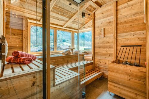 una sauna con paredes de madera y ventanas en una cabaña de madera en Apartmenthaus Wiesenhof, en Aschau
