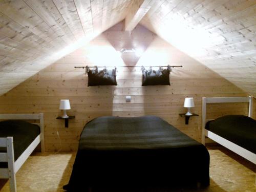 Cette chambre mansardée comprend deux lits et un plafond avec des lumières. dans l'établissement chalet de charme le contemporain, à Ney