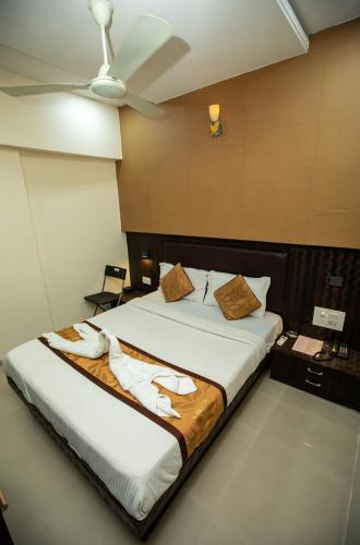 a bedroom with a large bed with a ceiling fan at Hotel J D Residency in Mumbai