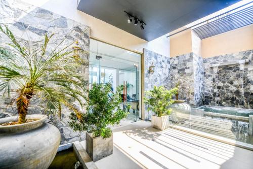 uma casa de banho com vasos de plantas e uma banheira em Oasis Riverside Hotel em Kalutara