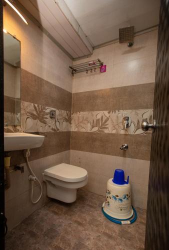 a bathroom with a toilet and a sink at Hotel J D Residency in Mumbai