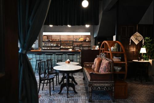 un restaurant avec une table et des chaises ainsi qu'un bar dans l'établissement Tim Mansion, à Bangkok