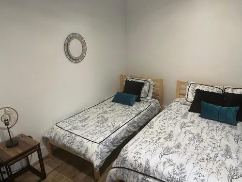 Un dormitorio con dos camas y un espejo en la pared. en Le Victor , en Saint-Raphaël