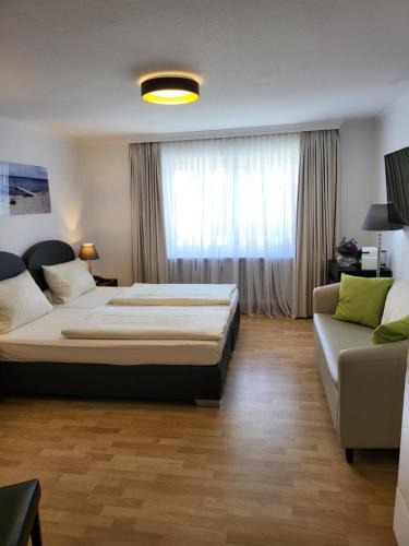 1 dormitorio con 1 cama grande y 1 sofá en Villa am Meer en Westerland