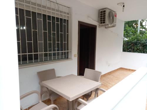 stół i krzesła w pokoju z oknem w obiekcie Vacation's Apartment w Durrës