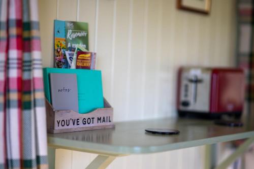 Una mesa con una caja que dice que tienes correo en The Shepherd's Shed at Accott Manor, 