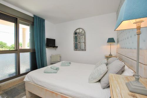 a bedroom with a large bed and a window at Stella Maris in Cala Pi