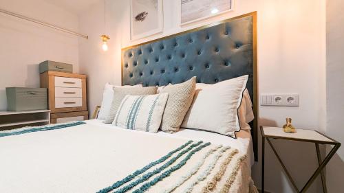 um quarto com uma cama grande e uma cabeceira azul em CARTAGO Poniente beach apartment em Benidorm