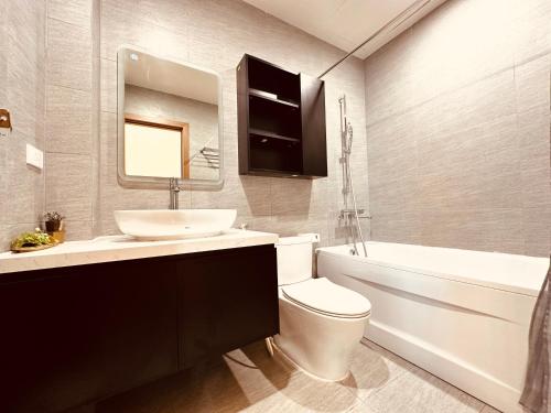 a bathroom with a sink and a toilet and a mirror at Warm & Cozy Apartment in Hai Phong