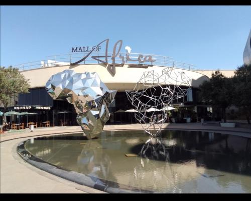 a fountain in front of a building with a sculpture in the water at Gallagher Midrand BnB in Midrand