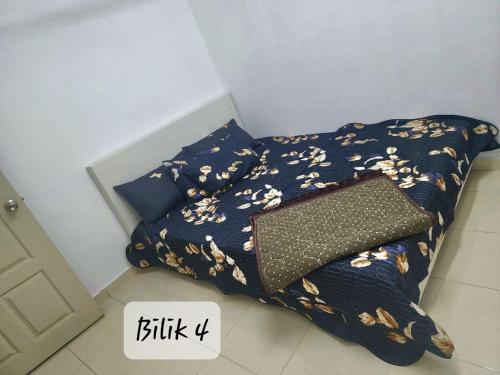 uma cama com um edredão e um saco em Ro-z Homestay em Rantau Panjang