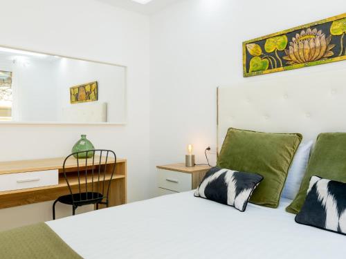 een slaapkamer met een wit bed en een bureau bij 9 Parque Tropical Apartamento Los Cristianos in Los Cristianos