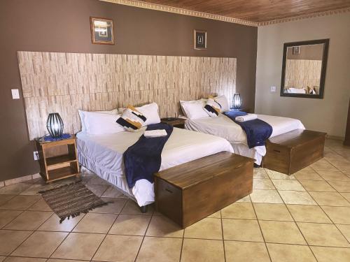 1 dormitorio con 2 camas y 2 mesitas de noche en The Wilds Lodge, en Kuruman
