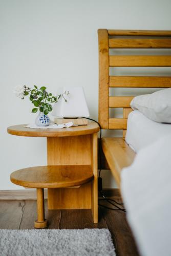 a table with a vase on it next to a bed at Ferienwohnung Morgensonne in Schützen am Gebirge