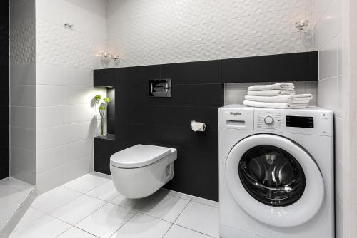 a bathroom with a washing machine and a toilet at Apartamenty City Tower od WroclawApartament-pl in Wrocław