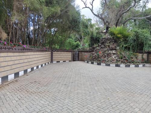 a courtyard with a fence and flowers and plants at Brooks Lodge in Nakuru
