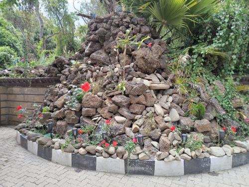 a large pile of rocks and plants in a garden at Brooks Lodge in Nakuru