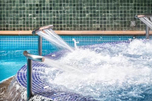 a water fountain in a swimming pool at Hotel Cala del Pi - Adults Only in Platja  d'Aro