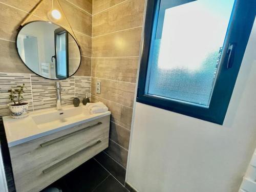 a bathroom with a sink and a mirror at Villa avec piscine proche plages in Vaux-sur-Mer