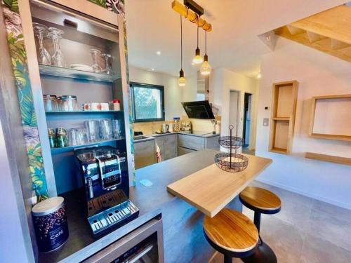 a kitchen with a table and two stools in a room at Villa avec piscine proche plages in Vaux-sur-Mer