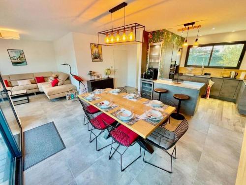 a dining table and chairs in a living room at Villa avec piscine proche plages in Vaux-sur-Mer