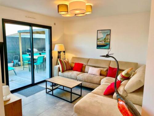 a living room with a couch and a table at Villa avec piscine proche plages in Vaux-sur-Mer