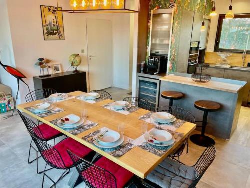 a table with chairs and plates on it in a kitchen at Villa avec piscine proche plages in Vaux-sur-Mer
