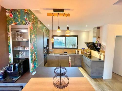 a large kitchen with a table and a counter at Villa avec piscine proche plages in Vaux-sur-Mer
