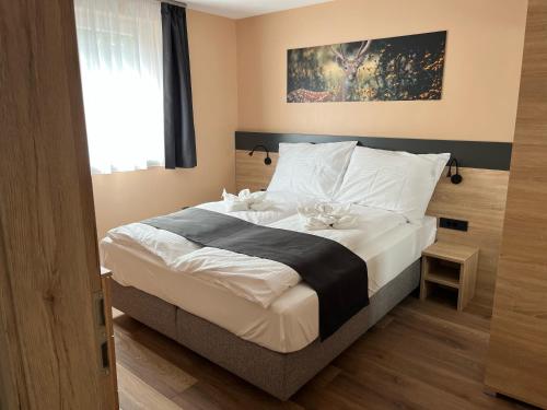 1 dormitorio con 1 cama con sábanas blancas y almohadas blancas en Sunset Bogács en Bogács