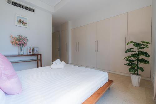 a bedroom with a white bed and a potted plant at Park view Avalon Apartment District 1 HCM City in Ho Chi Minh City