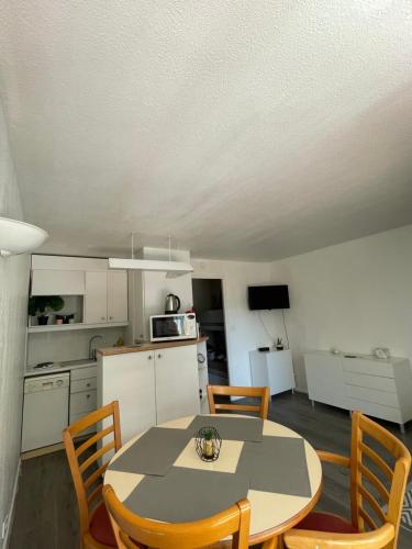 拉波勒的住宿－Appartement La Baule - Plage Benoît，厨房以及带桌椅的用餐室。