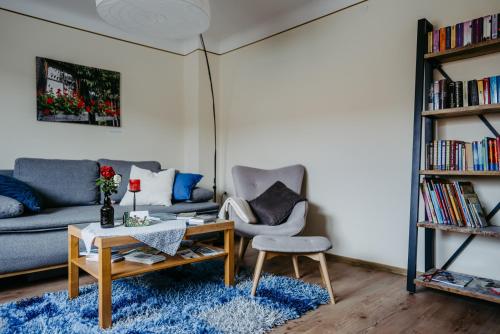 sala de estar con sofá, mesa y silla en Ferienwohnung Morgensonne, en Schützen am Gebirge