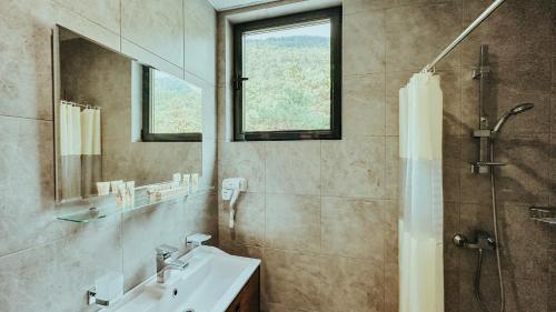 a bathroom with a sink and a shower and a mirror at Парк СПА Отель Нарт in Gagra