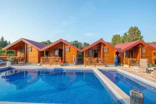 a resort with a swimming pool in front of a cabin at Apartments and bungalow Casa Palma in Ulcinj