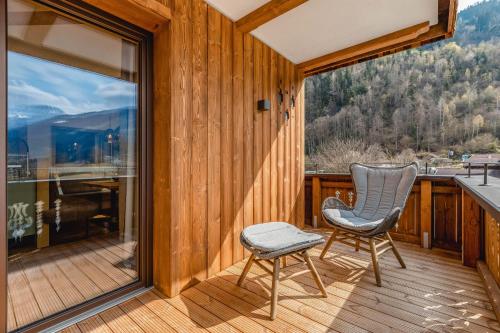 a room with a balcony with a chair and a window at Apartmenthaus Wiesenhof in Aschau