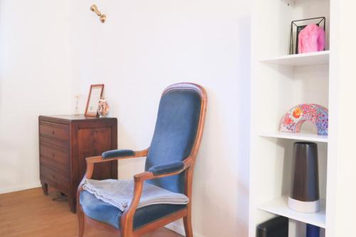 einen blauen Stuhl in einem Zimmer mit einer Kommode in der Unterkunft Le Tropical, Chic & Design in Wahlbach