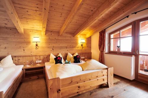 a bedroom with two beds in a wooden room at Berggasthof Platzlalm in Kaltenbach