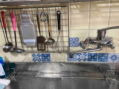 a kitchen sink with utensils on a wall at 桂浜龍馬に1番近い宿ペットと泊れる一軒家龍馬庵 in Kochi
