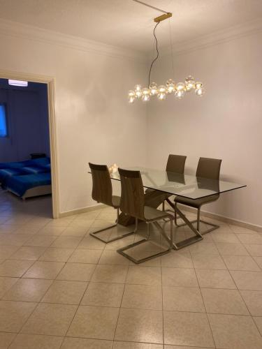 mesa de comedor con sillas y lámpara de araña en Appartement spacieux et agréable en Tánger