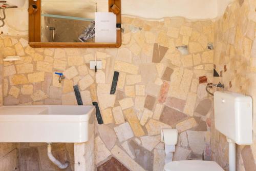 La salle de bains est pourvue d'un lavabo, de toilettes et d'un miroir. dans l'établissement Villetta Paola by BarbarHouse, à Borgagne