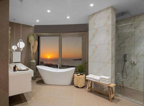 a bathroom with a tub and a view of the city at Ailla Yalıkavak in Bodrum City