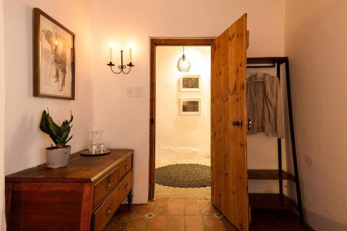 a room with a wooden door and a dresser and a hallway at The Cottage in the Valley - 3 bedroomed in Riebeek-Kasteel