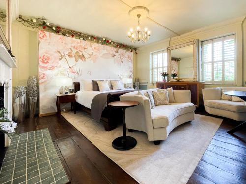 a bedroom with a bed and a couch and a table at Quob Park Old House Hotel & Spa in Fareham